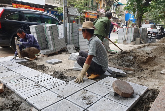Ẩn số về chất lượng, nguồn gốc đá Công nhân đang lát đá tự nhiên tại phố Hòa Mã (ngày 2/12)