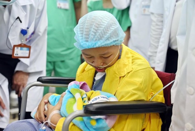 Con của người mẹ ung thư di căn được xuất viện Chị Liên hạnh phúc ôm con vào lòng - Ảnh: VNE