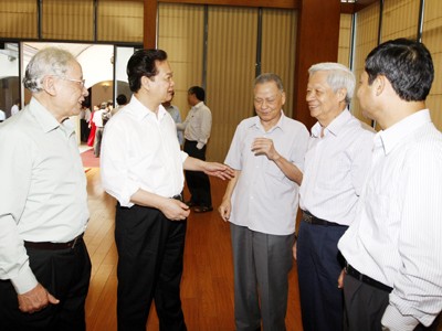 Kìm chế lạm phát - không thể dao động Thủ tướng và các chuyên gia kinh tế trao đổi bên lề buổi làm việc. Ảnh: TTXVN