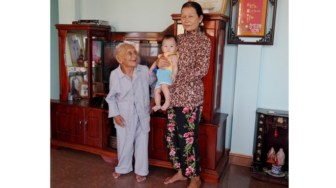 Bí quyết trường thọ của cụ ông 100 tuổi nói tiếng Pháp như gió Cụ Một bên cạnh con dâu và chắt nội. Cụ có hơn 40 cháu, chắt. Ảnh: Đoàn Nguyên.