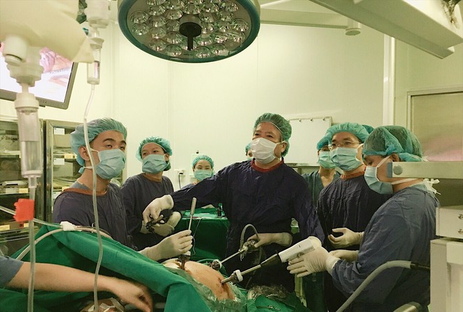 Khoa học không rào cản: Giấc mơ thành hiện thực GS.TS.BS Trần Bình Giang, Giám đốc Bệnh viện Hữu nghị Việt Đức trong một ca phẫu thuật (Người đứng giữa) (Nguồn ảnh: Bệnh viện Hữu nghị Việt Đức)