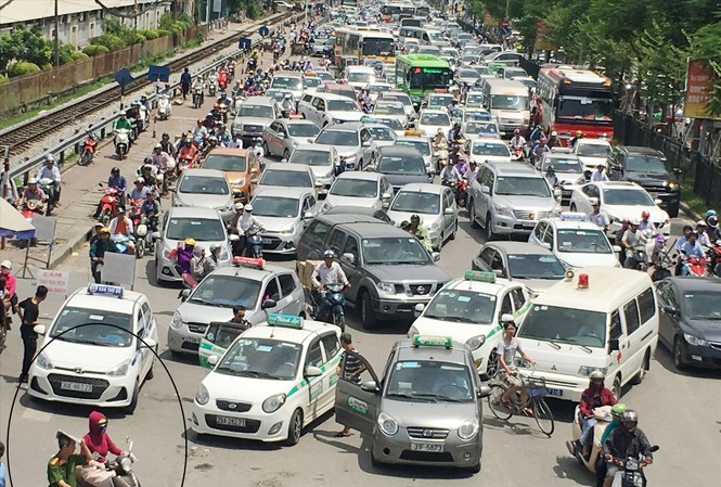 Cảnh sát, Thanh tra Giao thông chưa đoàn kết Đường Giải Phóng trước BV Bạch Mai ùn tắc nhưng taxi vẫn dàn hàng đứng đón, trả khách, còn công an có mặt (khoanh tròn) lấy báo che đầu
Ảnh: A.Trọng