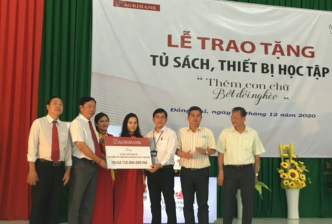 “Thêm con chữ bớt đói nghèo”: Acho con em đồng bào dân tộc đến trường ông Nguyễn Huy Trinh (thứ 2 từ trái qua) Giám đốc CN Đồng Nai trao tặng trang thiết bị cho đại diện nhà trường và lãnh đạo ngành giáo dục