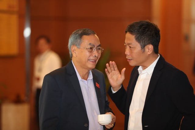 Bộ trưởng và Chủ nhiệm Uỷ ban có nên 'đổi vai'? Các đại biểu trao đổi bên hành lang Quốc hội. Ảnh Như Ý