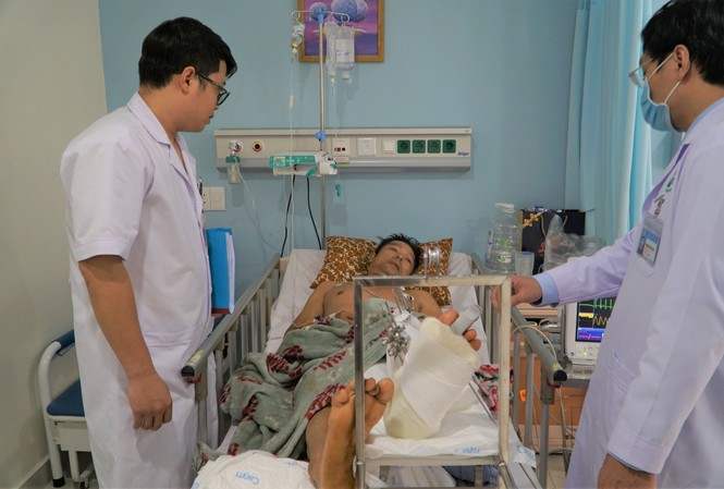 Vừa trả lời dứt câu hỏi, người đàn ông bị hai thanh niên lạ mặt chém gần đứt lìa chân Các bác sĩ chăm sóc cho bệnh nhân sau mổ.