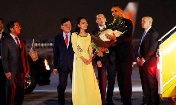 Chuyến thăm lịch sử nâng tầm quan hệ Tống thống Obama nhận hoa từ nữ sinh Việt khi đặt chân xuống sân bay Nội Bài. Ảnh: Reuters.