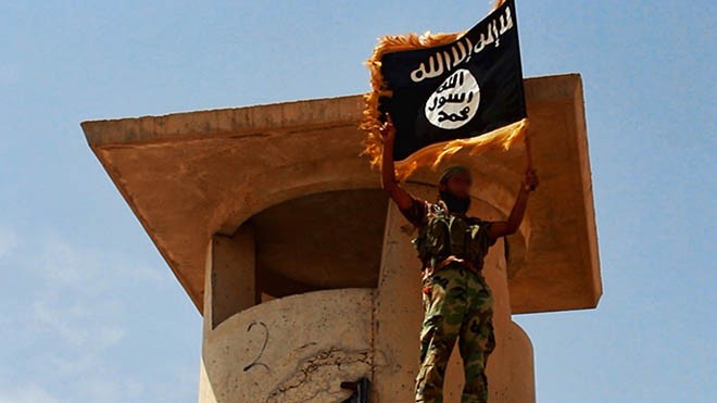 Tình báo Mỹ và Anh phớt lờ cảnh báo tấn công Iraq ISIS giơ cờ chiến thắng sau khi chiếm giữ một trạm kiểm soát quân sự tại miền bắc Iraq (Ảnh: RT)