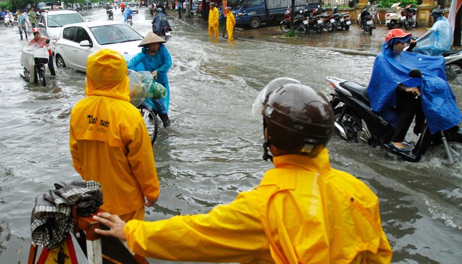 Hà Nội: Không thể chấp nhận cứ mưa là ngập Công nhân cấp thoát nước Hà Nội đứng túc trực tại điểm ngập trên đường Lê Trọng Tấn. ảnh: Như Ý