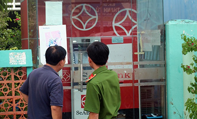 Máy ATM bị cạy, mất hơn 100 triệu đồng Cảnh sát khám nghiệm hiện trường máy ATM bị trộm. Ảnh: Hồ Nam.