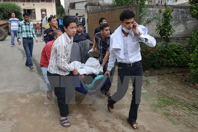 Bản tin 8H: Đã có gần 1.500 người chết vì động đất ở Nepal Nhân viên y tế Nepal chuyển các nạn nhân bị thương sau trận động đất ngày 25/4 đi chữa trị tại khu vực Lalitpur, ngoại ô Kathmandu. (Ảnh: AFP/TTXVN)