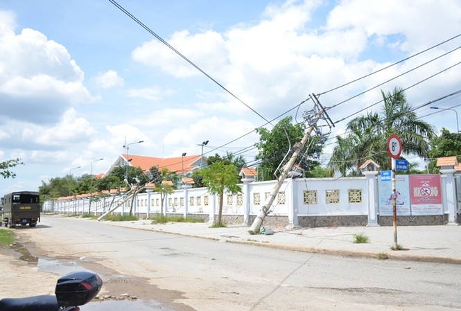 Xe ben chở đất “đốn hạ” hàng loạt trụ điện Một số trụ điện bị kéo ngã vào bức tường.