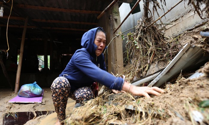 Bà Vang Thị Bình (bản Hòa Sơn, xã Tà Cạ) nức nghẹn bới bùn tìm tài sản Ảnh: Cảnh Huệ