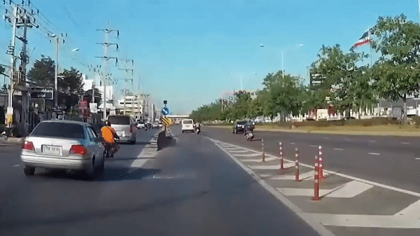 Xe máy mắc dải phân làn, ngã lăn ra đường