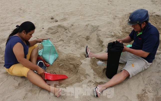 Dân Nha Trang ra biển xúc cát về chống bão ảnh 2