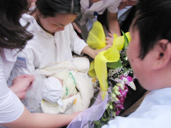 Cbị Thơm nhận cháu bé trong tiếng vỗ tay, reo hò của hàng ngàn người. Ai cũng xúc động, vui mừng cho niềm hạnh phúc của gia đình chị. Ảnh: Lãng Phong