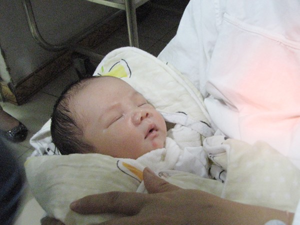 Cháu bé trông vẫn bụ bẫm sau gần sáu ngày xa mẹ. Để tiện việc chăm sóc cho cả mẹ và con, các bác sỹ quyết định chăm sóc cháu bé ở Khoa Sơ sinh, chị Thơm vẫn nằm trên khoa sản. Khi nào sức khoẻ cả hai mẹ con hồi phục, sẽ cho hai mẹ con ở cùng nhau. Ảnh: Lãng Phong