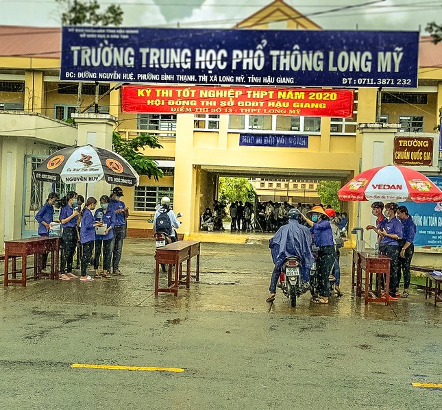 Cảm động tình nguyện viên dầm mưa hỗ trợ thí sinh thi tốt nghiệp THPT ảnh 1