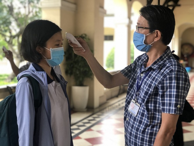 Thí sinh đeo khẩu trang, được đo thân nhiệt khi làm thủ tục thi tốt nghiệp THPT - ảnh 1