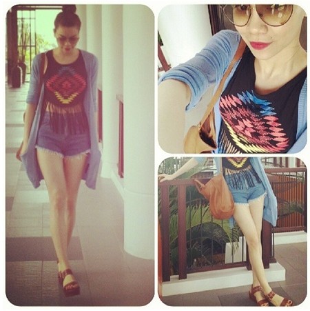 Hà Hồ trẻ trung với quần soóc denim, áo coptop, và cô cũng không quên mang thêm chiếc áo khoác cardigan đơn giản và xăng đan, túi da đeo chéo để có một bộ cánh hoàn hảo chào hè