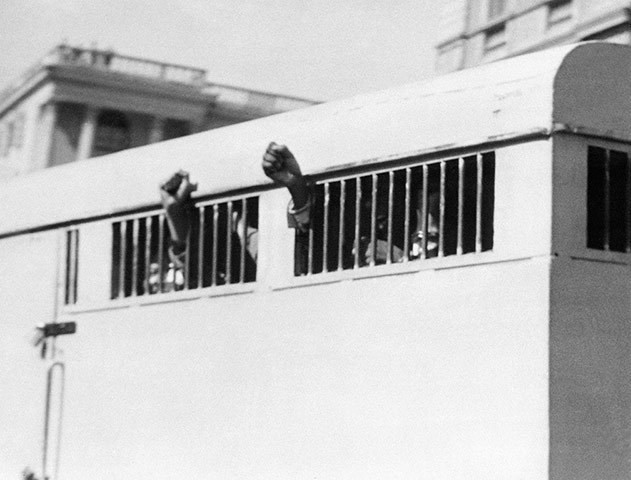 Năm 1964: Tám người đàn ông, trong đó có Nelson Mandela, đã giơ cao nắm tay thách thức qua cửa của một chiếc xe chở phạm nhân. Phiên tòa xét xử ở Tòa án Tối cao Pretoria đã kết án ông Mandela bị tù chung thân vì tội phá hoại, âm mưu phản quốc. (Nguồn: Getty)