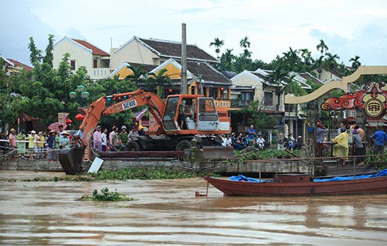 Dù đã được mở nắp khai thông ở điểm giữa cầu nhưng do bèo, rác dồn đọng sâu cả mét nên nước vẫn không thể chảy khiền tràn lên các tuyến phố
