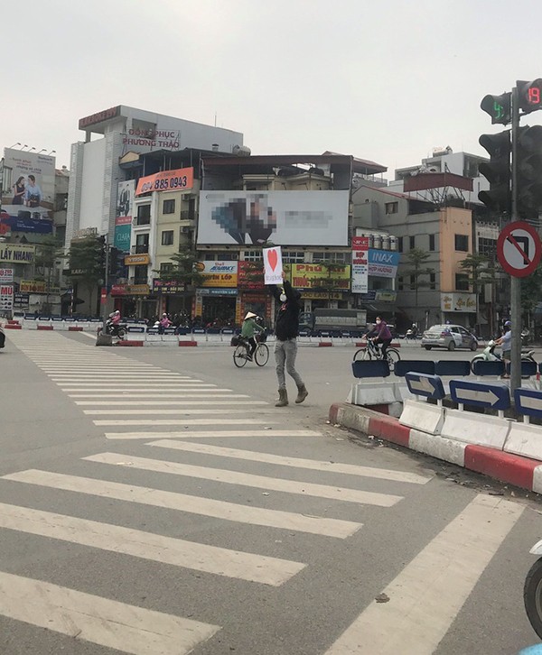 Chàng trai ngoại quốc cầm biển hiệu