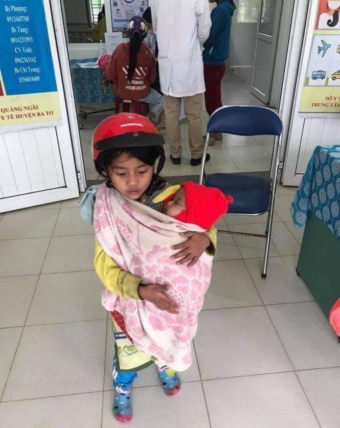 Xôn xao hình ảnh bé gái 7 tuổi bế đứa em bụ bẩm, tưởng như to bằng nửa cô chị đi tiêm phòng - ảnh 1