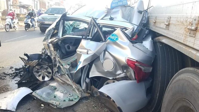 Taxi nát bét sau khi bị cuốn vào gầm xe tải - ảnh 1