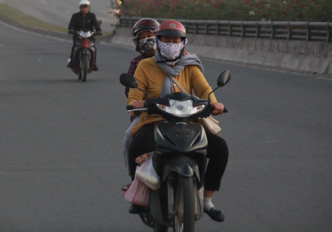 Người Sài Gòn khoác áo mưa, quấn khăn... chống lạnh buổi sáng - ảnh 1