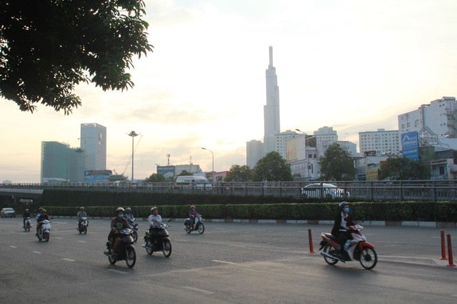 Người Sài Gòn khoác áo mưa, quấn khăn... chống lạnh buổi sáng - ảnh 14
