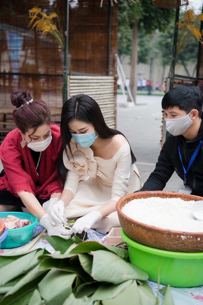 Hoa hậu Đỗ Thị Hà hào hứng gói bánh chưng, được các em học sinh 'bao vây' xin chữ ký - ảnh 6