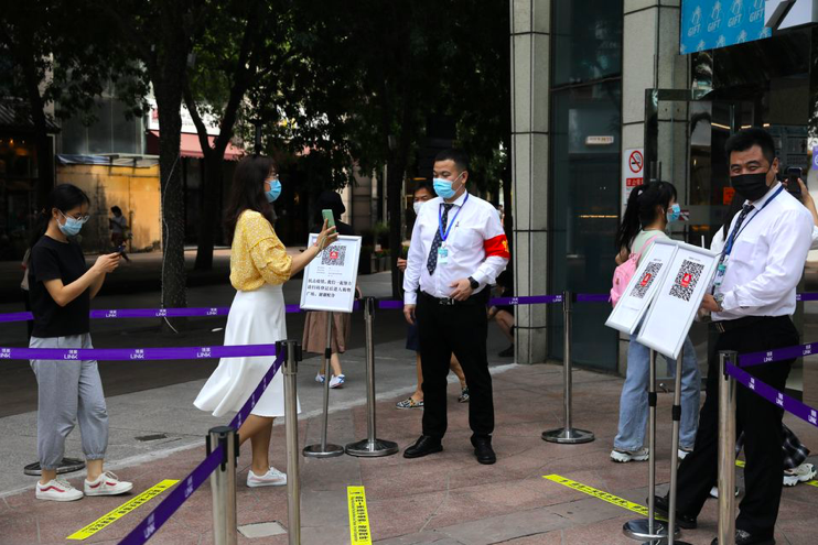 Một phụ nữ trình chứng nhận tiêm vắc xin trước khi vào trung tâm thương mại ở Bắc Kinh ngày 23/8. (Ảnh: Reuters)