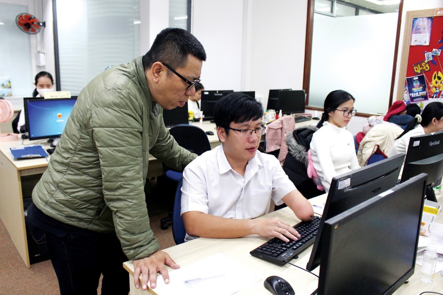Anh Trần Mạnh Huy, Tổng Giám đốc VBPO (bìa trái) đang trao đổi công việc cùng Nguyễn Thành Nhân – Trưởng phòng dự án. Ảnh: Giang Thanh