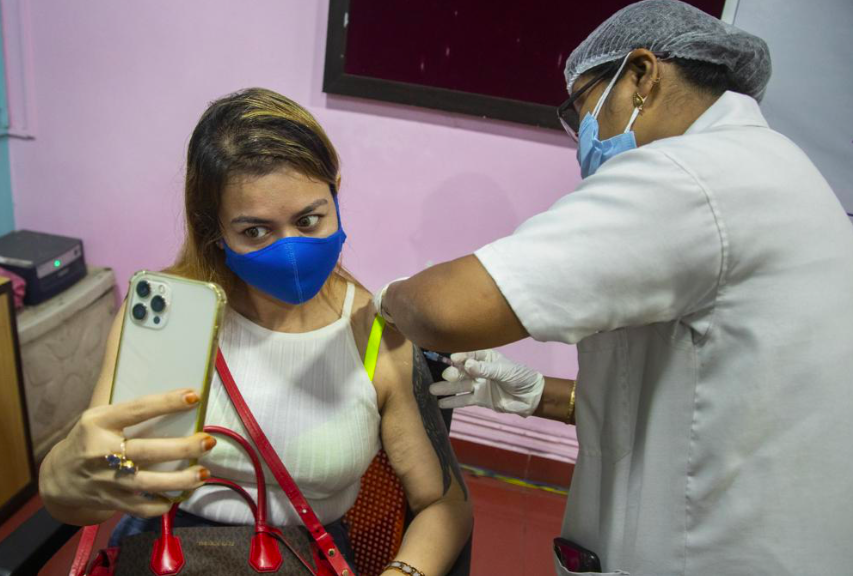 Một phụ nữ Ấn Ðộ tự chụp ảnh khi đang được tiêm vắc-xin ở bang Assam ngày 17/5. Ảnh: AP