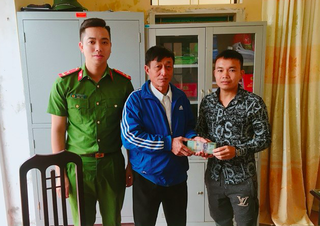 Anh Lương Văn Phú (bìa phải) trả lại 38 triệu đồng đã nhặt được trên đường cho ông Bùi Xuân Hỗ - Ảnh: Hoàng Long