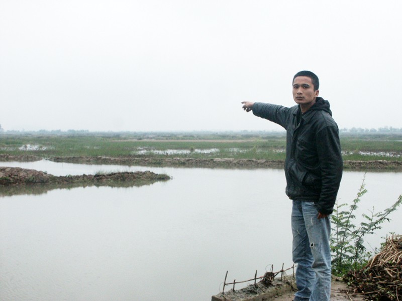 Con trai trưởng của ông Lê Đình Thảo đang chỉ tay về đầm nước từng là của gia đình anh