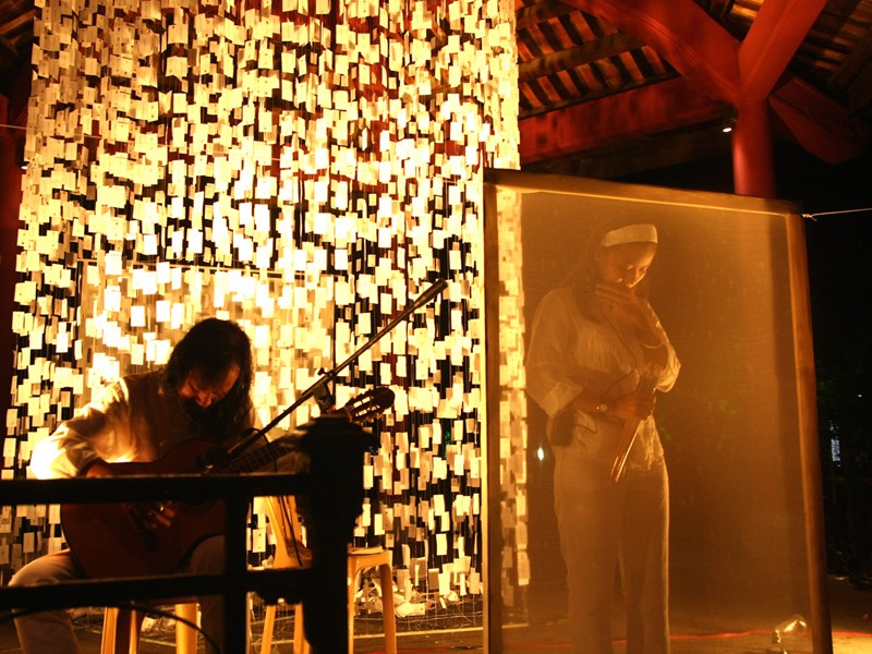 Nhà thơ Chiêu Anh Nguyễn trình diễn thơ trên sân khấu, đệm đàn: nghệ sĩ MPK Phước Khùng. Ảnh: Trần Đỗ Nghĩa