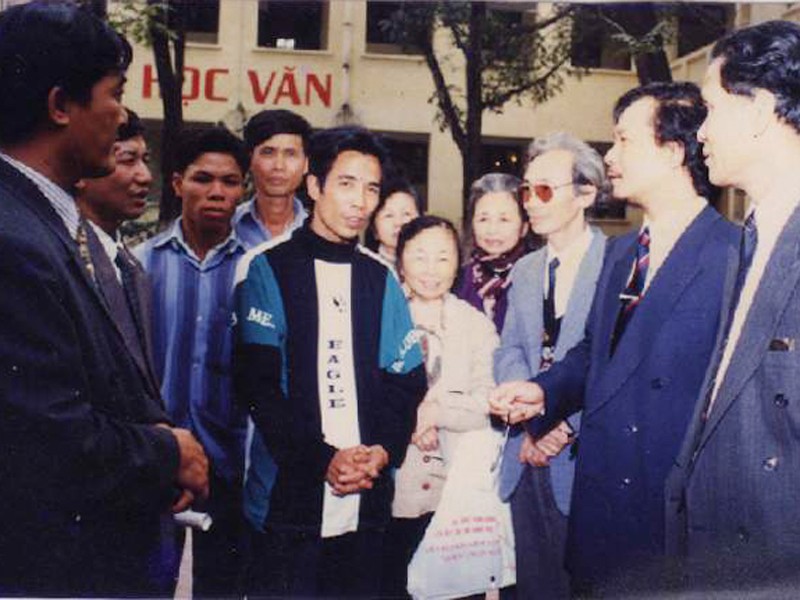 Ông Nguyễn Văn Liên (người chắp tay đứng giữa) đang kể chuyện tìm mộ liệt sĩ