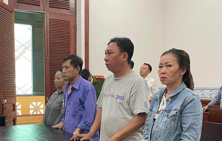 Cựu cán bộ công an Phạm Quang Tiến (áo xanh, thứ 3 phải sang) tại phiên tòa,