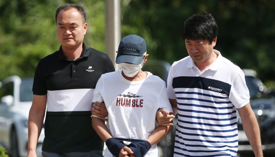 Người đàn ông Hàn Quốc bị tình nghi bạo hành người vợ Việt Nam bị cảnh sát dẫn đi. (Ảnh: Yonhap)