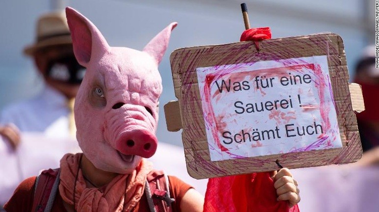 Một người biểu tình phản đối bên ngoài cuộc họp báo ở Gütersloh ngày 21/6. (Ảnh: CNN)