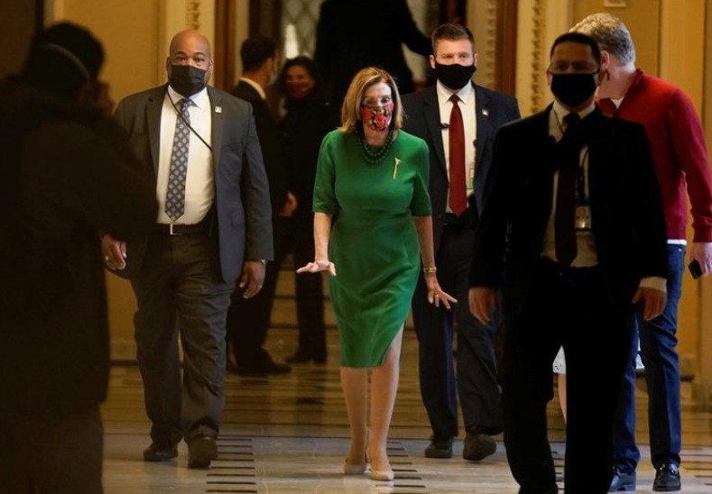 Chủ tịch Hạ viện Mỹ Nancy Pelosi (váy xanh) bước ra sau phiên họp ngày 21/12 của Hạ viện về gói cứu trợ mới. (Ảnh: Reuters)