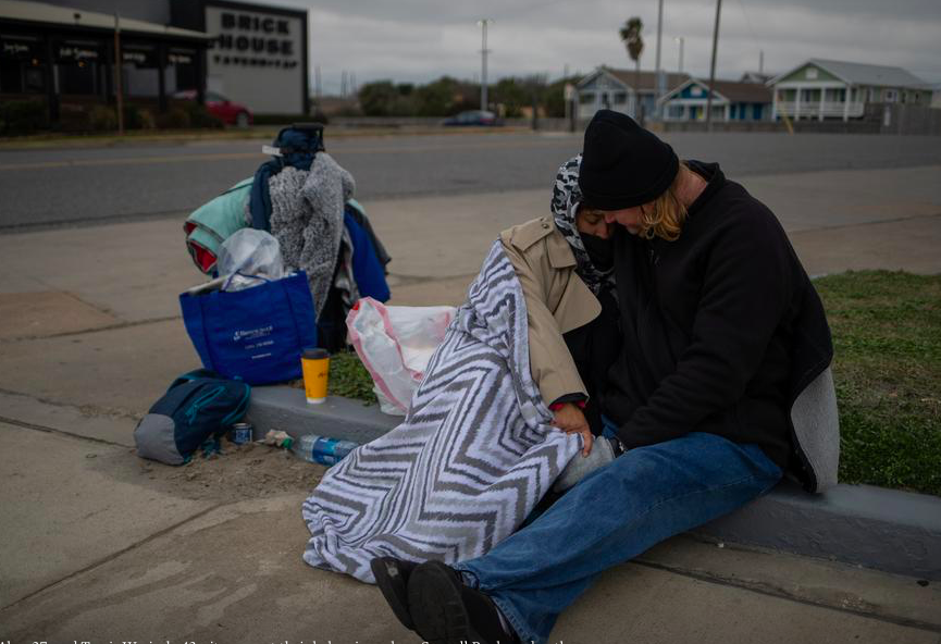 Một cặp vợ chồng người Texas ngồi sát bên nhau bên lề đường. Họ cho biết họ bị mất nhà sau khi mất việc năm 2020 vì đại dịch COVID-19. (Ảnh: Reuters)