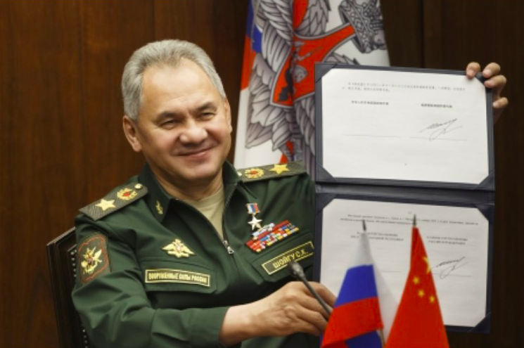 Bộ trưởng Quốc phòng Nga Sergei Shoigu giơ bản lộ trình hợp tác quân sự Nga - Trung đã ký với người đồng cấp Trung Quốc ngày 23/11. (Ảnh: AP)