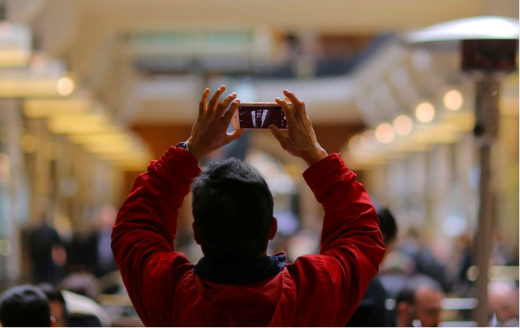Một người đang dùng điện thoại chụp ảnh trong trung tâm thương mại ở Sydney, Úc. (Ảnh: Reuters)