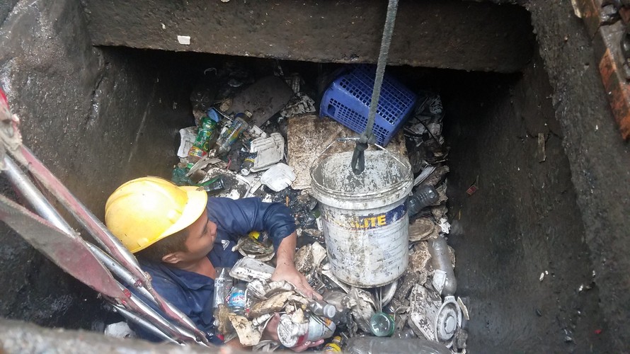 Công nhân ngâm mình dưới cống ở 'rốn ngập' Sài Gòn vớt rác