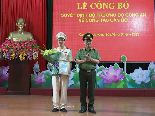 Đại tá Vũ Hồng Quang (bìa trái) nhận Quyết định, hoa chúc mừng từ lãnh đạo Bộ công an .Ảnh: G. Hưng