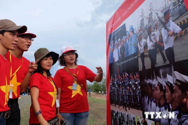 Sinh viên xem ảnh tại triển lãm“Tự hào biển đảo Việt Nam” tại Kiên Giang. (Ảnh: Đoàn Bắc/TTXVN)