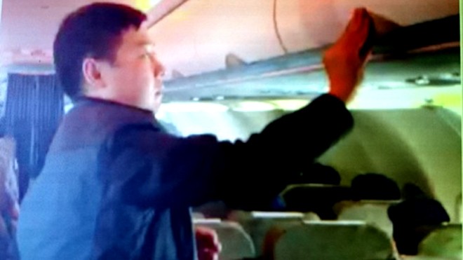 Hình ảnh hành khách Zhang Giang (Trung Quốc) ăn cắp đồ tại giá hành lý trên chuyến bay VN 600 Bangkok (Thái Lan) - TP HCM chiều 19/1 cũng đã bị tiếp viên Vietnam Airlines bắt quả tang và quay clip làm bằng chứng