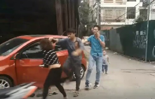 Người chồng hùng hổ lao vào đánh vợ bất chấp sự can ngăn của người đi đường. Ảnh cắt từ clip